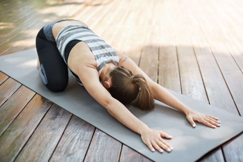 young woman stretching her back after long yoga session doing exercises her backyard neighbours envy